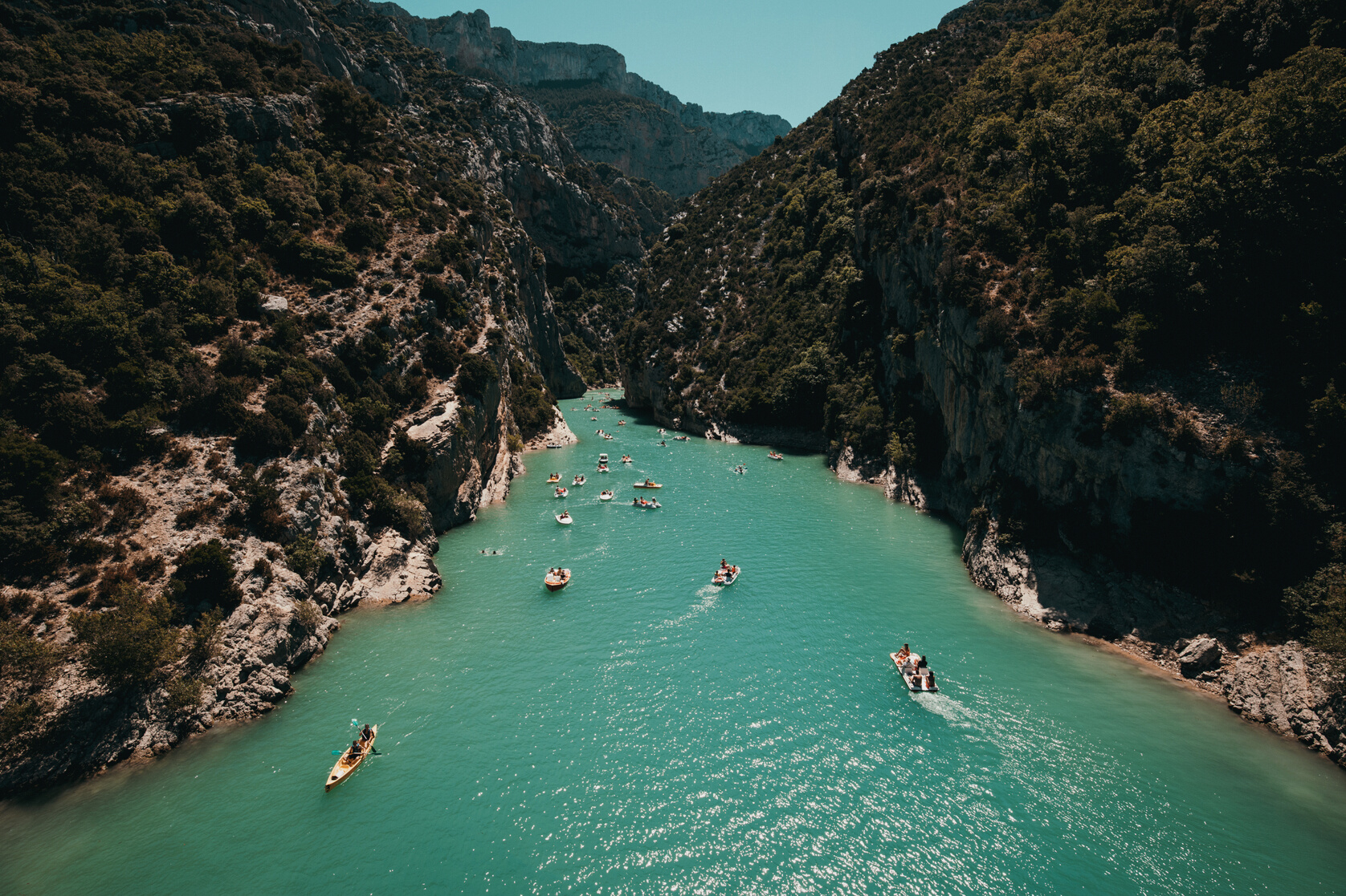 Photo of People Riding Kayaks Near Mountains